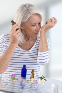 essential oils for mood, senior woman smelling essential oils as an aromatherapy solution for her anxiety